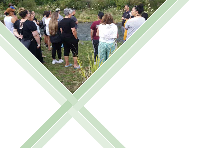 A group of Māori talk at the banks of an awa